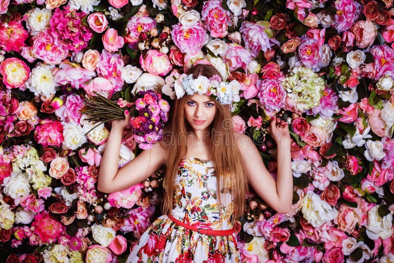 A Beautiful Young Girl with Flowers Bouquet Near a Floral Wall. Stock ...