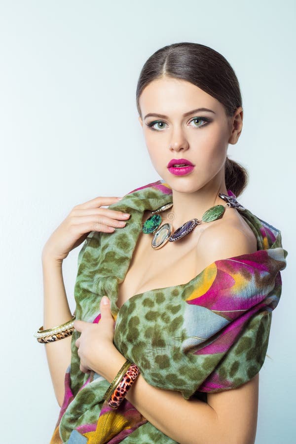 Beautiful young girl with a hat bright makeup with color beautiful expensive scarf at the neck on white background in Studio