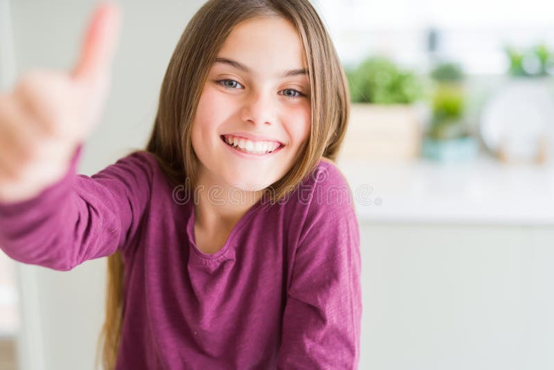 Beautiful young girl kid doing happy thumbs up gesture with hand