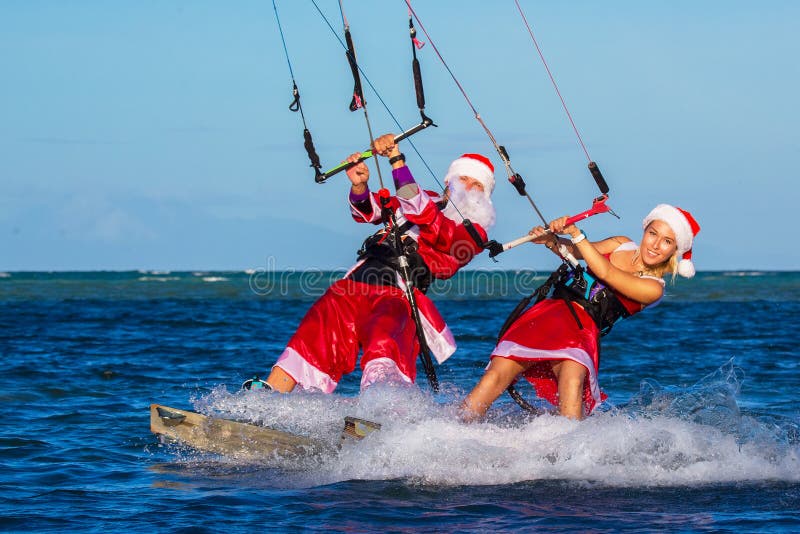Beautiful young girl and man on the kites in the costume of Santa Claus. Christmas and New year on a tropical island. Extreme stock photos Beautiful young girl and man on the kites in the costume of Santa Claus. Christmas and New year on a tropical island. Extreme stock photos