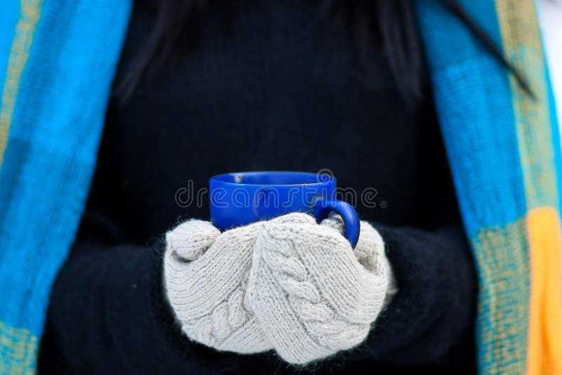 Beautiful young girl portrait on winter background. A charming young lady walking in a winter forest. Attractive woman with Cup.