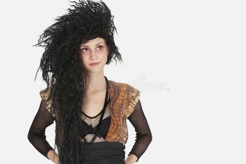 Beautiful young Goth woman with teased hair looking away over gray background stock image Beautiful young Goth woman with teased hair looking away over gray background stock image