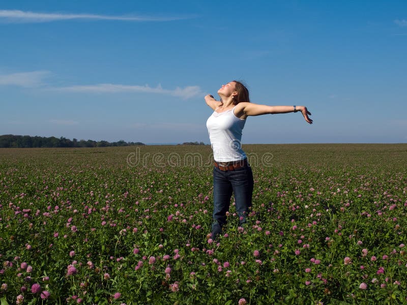 Beautiful young happy woman in a field