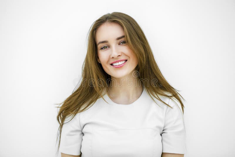 Beautiful young happy woman posing against a white wall