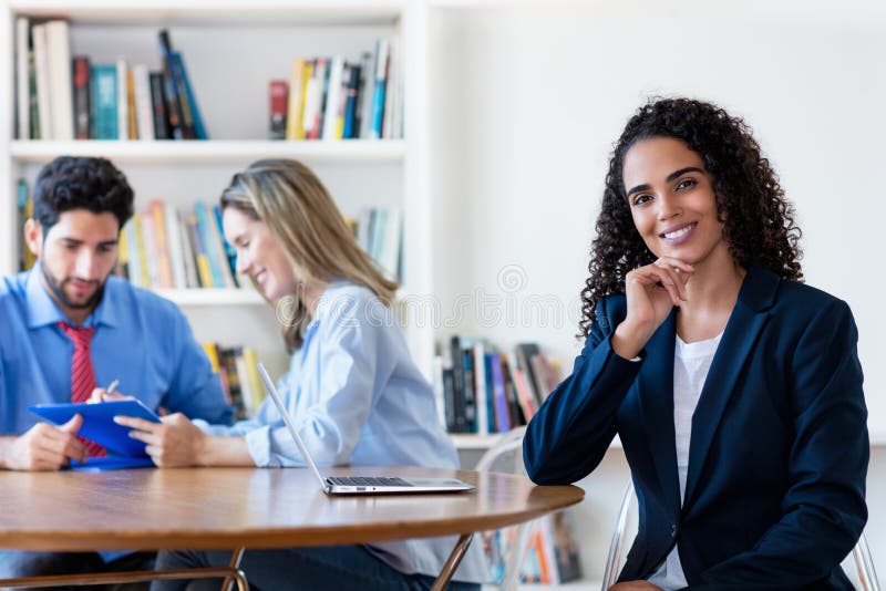 Beautiful young hispanic businesswoman at desk royalty free stock images
