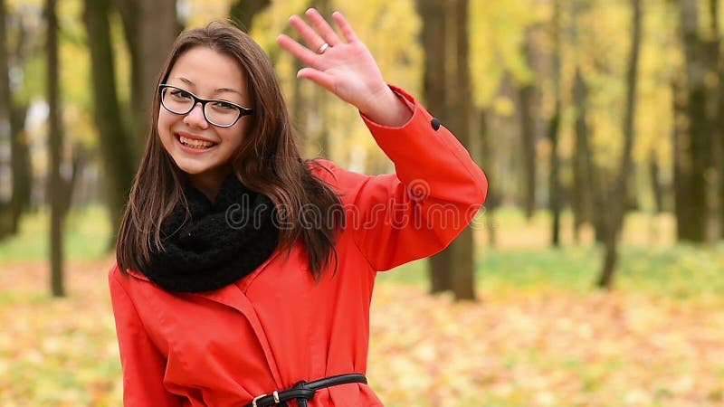 Beautiful young Korean girl waving hand to friends