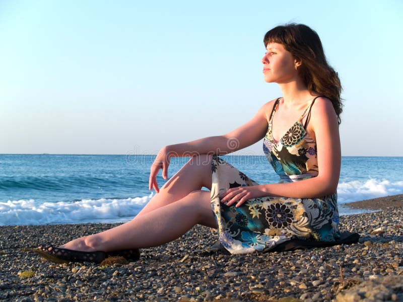 Beautiful Young Lady Sitting on Pebble