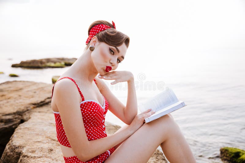 Beautiful Young Lovely Pin Up Girl Reading Book While Sitting Stock