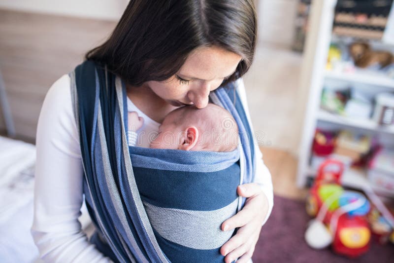Young Mother Holding Sleeping Baby In Baby Sling. Stock 