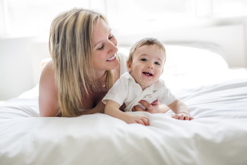 Beautiful Young Mother and Son Lying Together on a Bed Stock Photo ...