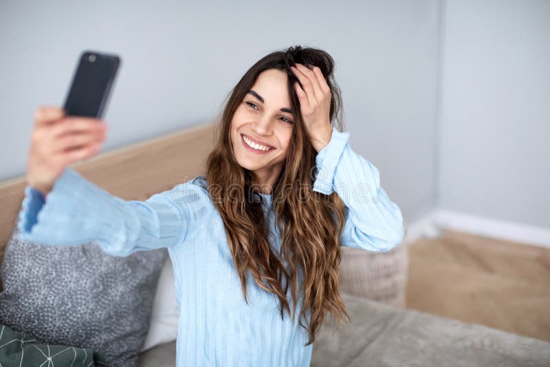 Beautiful young smiling woman with a phone in her hands takes a selfie stock photos Beautiful young smiling woman with a phone in her hands takes a selfie stock photos