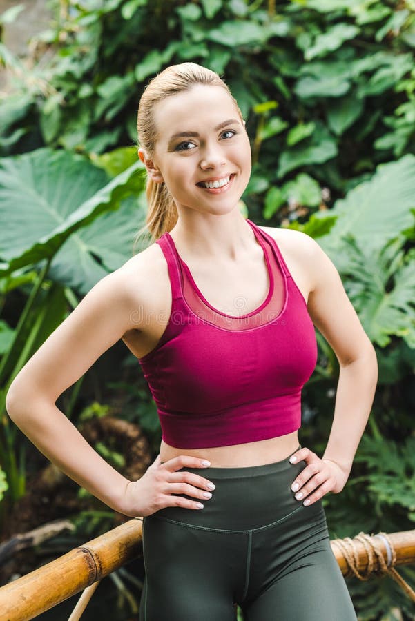 beautiful young sportswoman with arms akimbo looking at camera stock photos beautiful young sportswoman with arms akimbo looking at camera stock photos