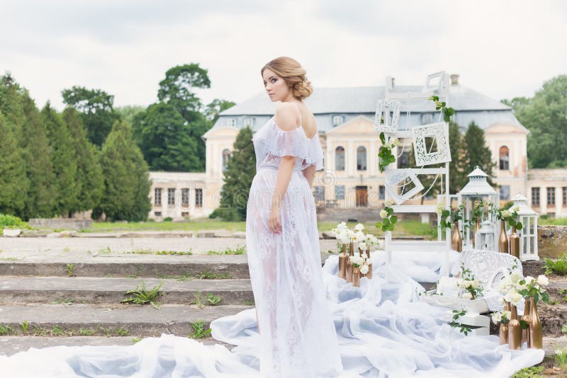 Beautiful young sweet blonde girl with wedding bouquet in the hands of the boudoir in a white dress with evening hairstyle walks royalty free stock images Beautiful young sweet blonde girl with wedding bouquet in the hands of the boudoir in a white dress with evening hairstyle walks royalty free stock images