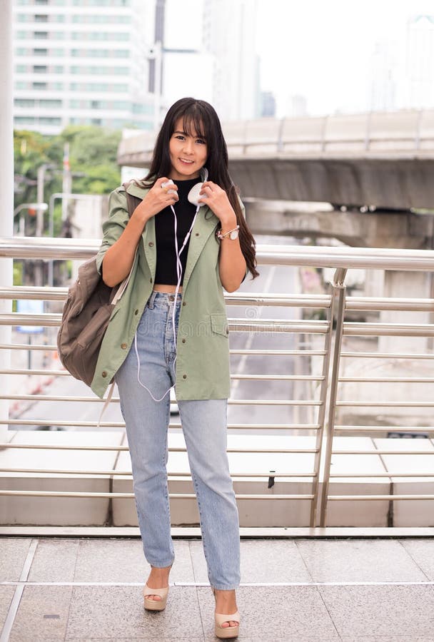 Beautiful young teen using headphones and listening to music at shopping center stock photo Beautiful young teen using headphones and listening to music at shopping center stock photo