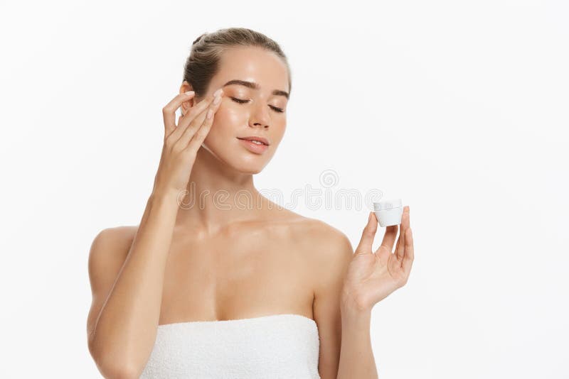 Beautiful young woman applying cosmetic cream treatment on her face isolated on white background royalty free stock photos Beautiful young woman applying cosmetic cream treatment on her face isolated on white background royalty free stock photos