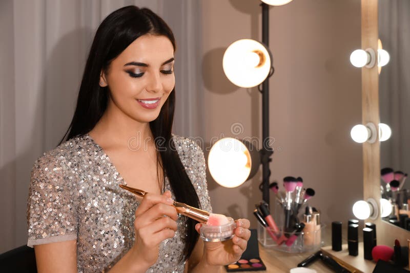Beautiful Young Woman Applying Makeup Near Mirror In Room ...