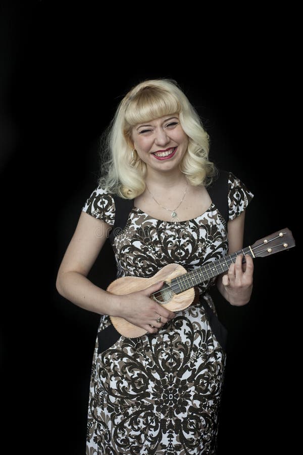Beautiful Young Woman with Blond Hair Playing Ukulele