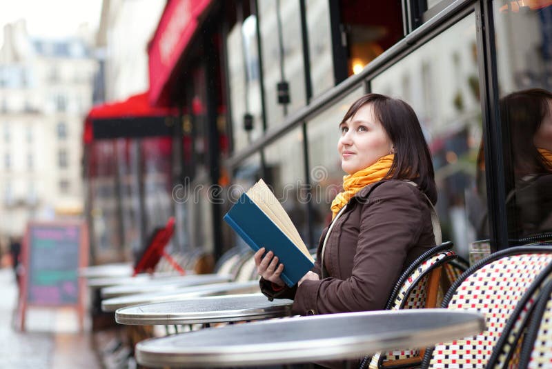 Beautiful young woman with a book in cafe