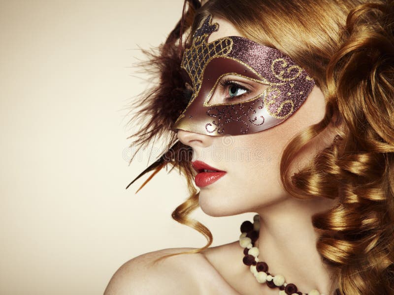 Beautiful young woman in brown venetian mask