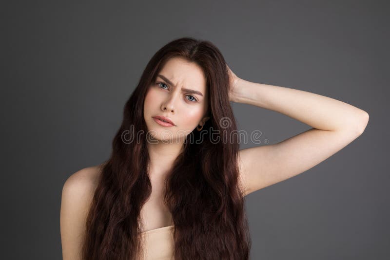 Beautiful young woman with brunette hair suffers from terrible headaches and compresses the head with fingers stock photos Beautiful young woman with brunette hair suffers from terrible headaches and compresses the head with fingers stock photos