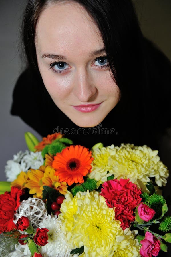 Beautiful young woman with bunch of flowers stock image Beautiful young woman with bunch of flowers stock image