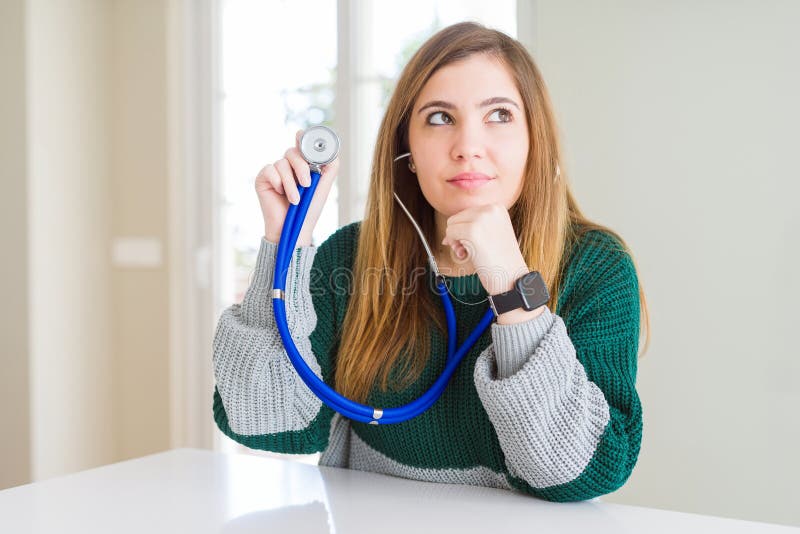 Beautiful young woman checking health with stethoscope serious face thinking about question, very confused idea