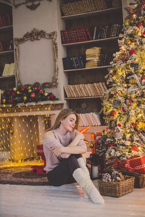 Beautiful Young Woman in a Christmas Interior. Dressing a Christmas