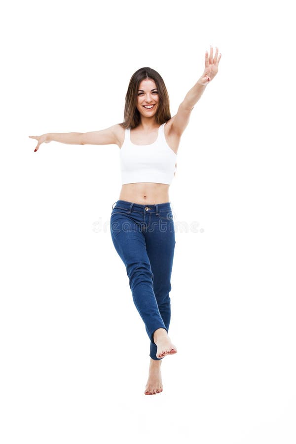 Beautiful young woman dancing over white background.