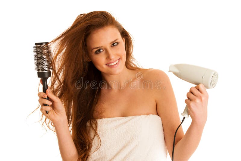 Beautiful young woman dries hair with a blow dryer