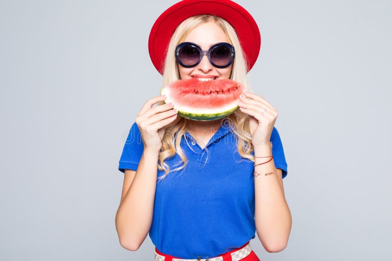 Beautiful young woman eat juicy watermelon over gray stock photography Beautiful young woman eat juicy watermelon over gray stock photography