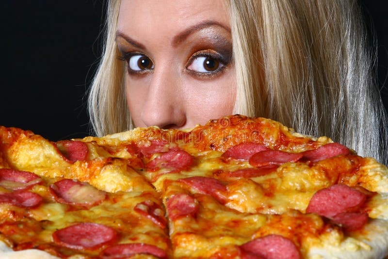 Beautiful young woman eating pizza