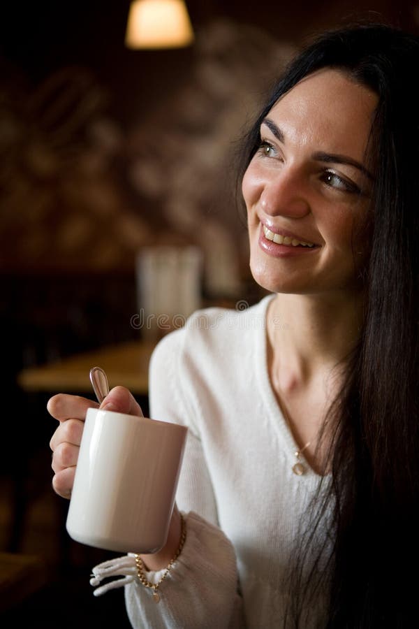 Beautiful young woman enjoying latte coffee