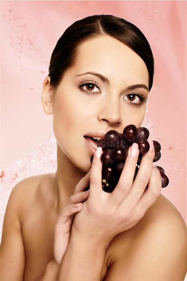 Beautiful young woman with grape
