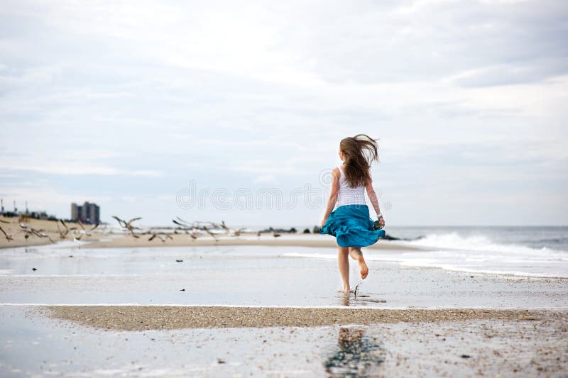 Beautiful young woman has fun on the ocean shore