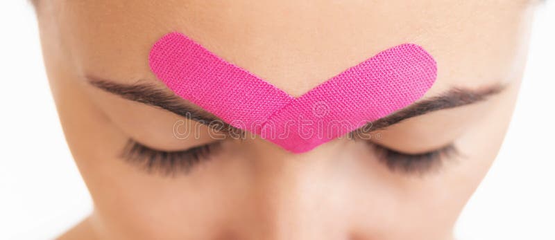 Woman with kinesio tape over eyebrows. stock photo