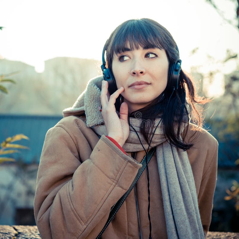 Beautiful young woman listening to music headphones