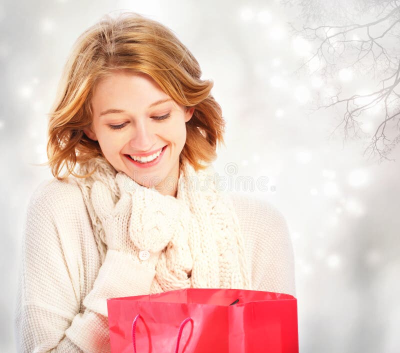 Beautiful young woman looking at a gift bag