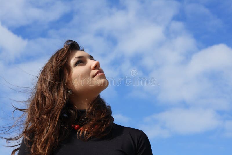 Beautiful young woman looking into the sky