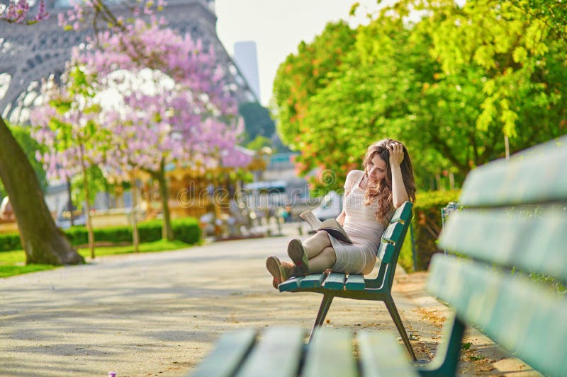 Beautiful young woman in Paris reading on the bench outdoors stock images Beautiful young woman in Paris reading on the bench outdoors stock images
