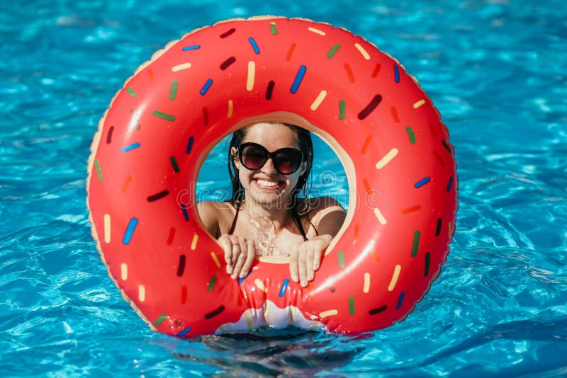 Beautiful young woman with pink donut circle have rest