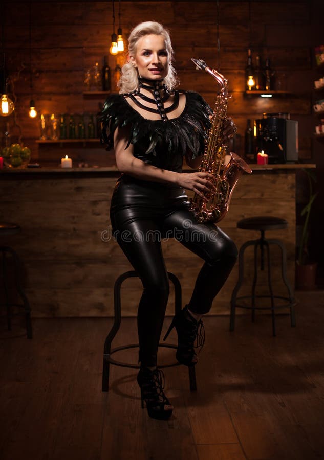 Beautiful young woman playing on saxophone in a vintage pub royalty free stock photo Beautiful young woman playing on saxophone in a vintage pub royalty free stock photo