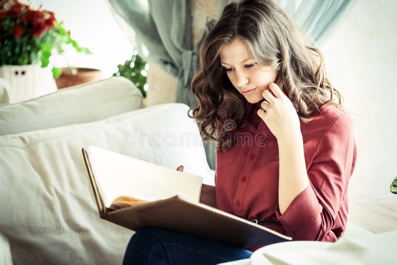 Beautiful young woman reading menu while sitting at the restaurant or cafe stock photos