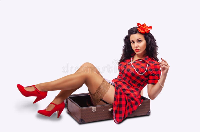 Young woman pinup style sitting in a suitcase