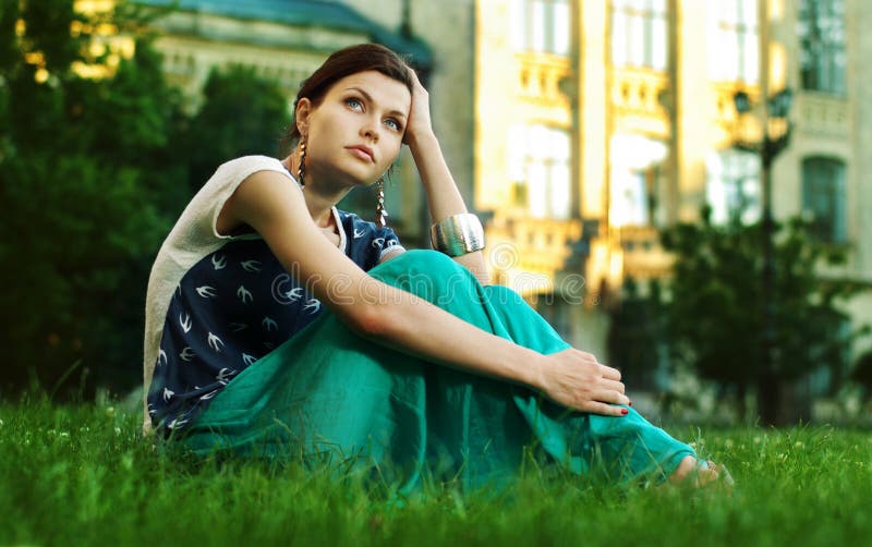 Beautiful Young Woman relaxing on a grass