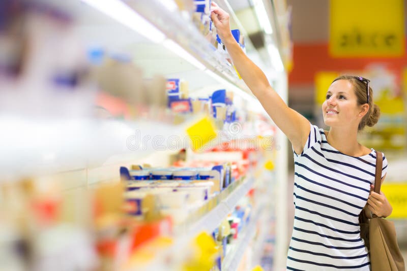 Beautiful young woman shopping for diary products at a grocery royalty free stock photos Beautiful young woman shopping for diary products at a grocery royalty free stock photos