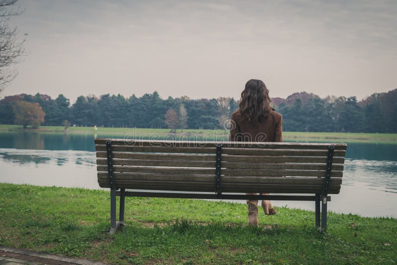 Beautiful young woman sitting on a bench in a city park royalty free stock images Beautiful young woman sitting on a bench in a city park royalty free stock images