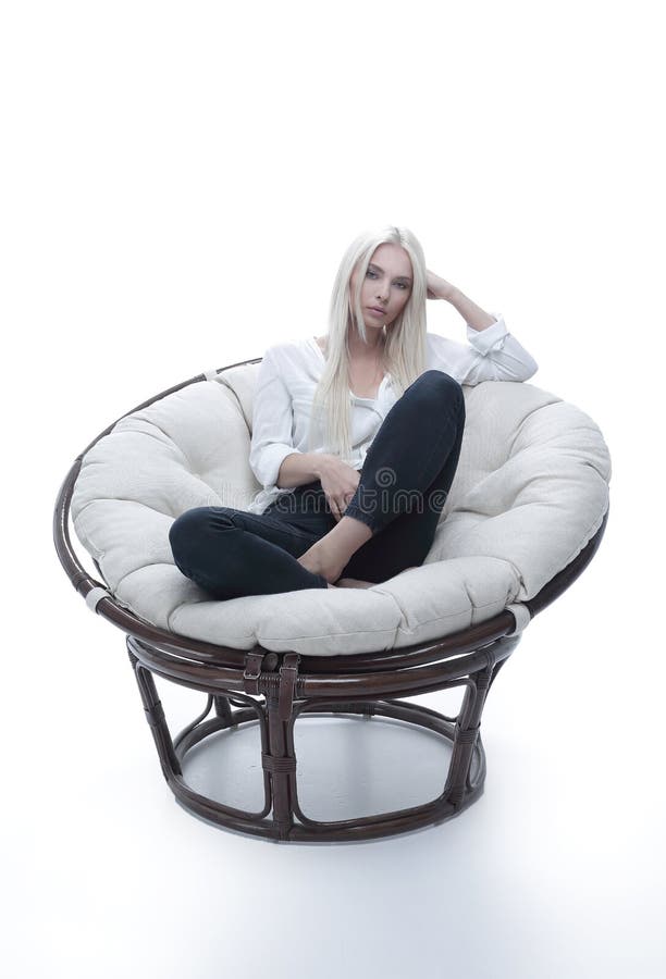 Beautiful young woman sitting on the couch in a large comfortable armchair.