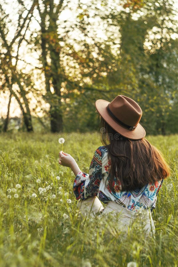 Beautiful Young Woman sitting on the field in green grass and blowing dandelion. Outdoors. Enjoy Nature. Healthy Smiling Girl on royalty free stock photos Beautiful Young Woman sitting on the field in green grass and blowing dandelion. Outdoors. Enjoy Nature. Healthy Smiling Girl on royalty free stock photos