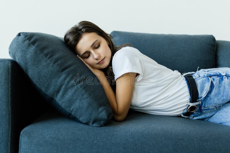Beautiful Young Woman Sleeping On The Couch In The Living Room Stock