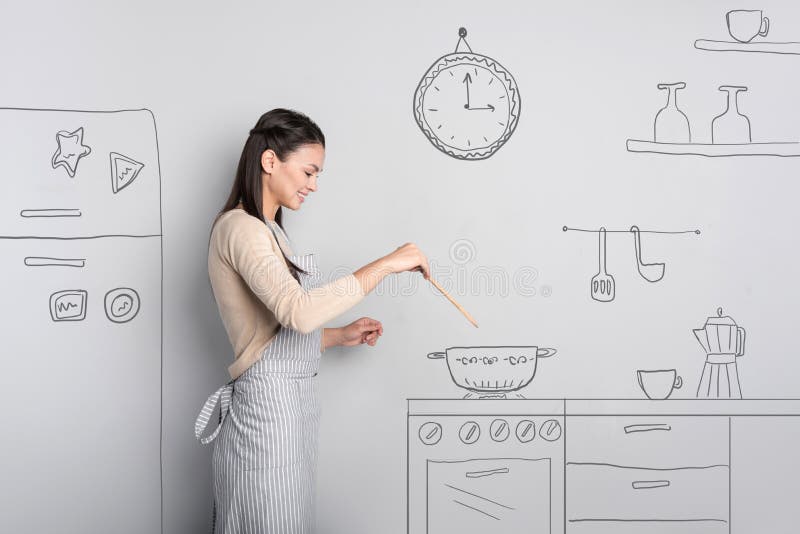 Beautiful young woman smiling while cooking at home royalty free stock photos Beautiful young woman smiling while cooking at home royalty free stock photos